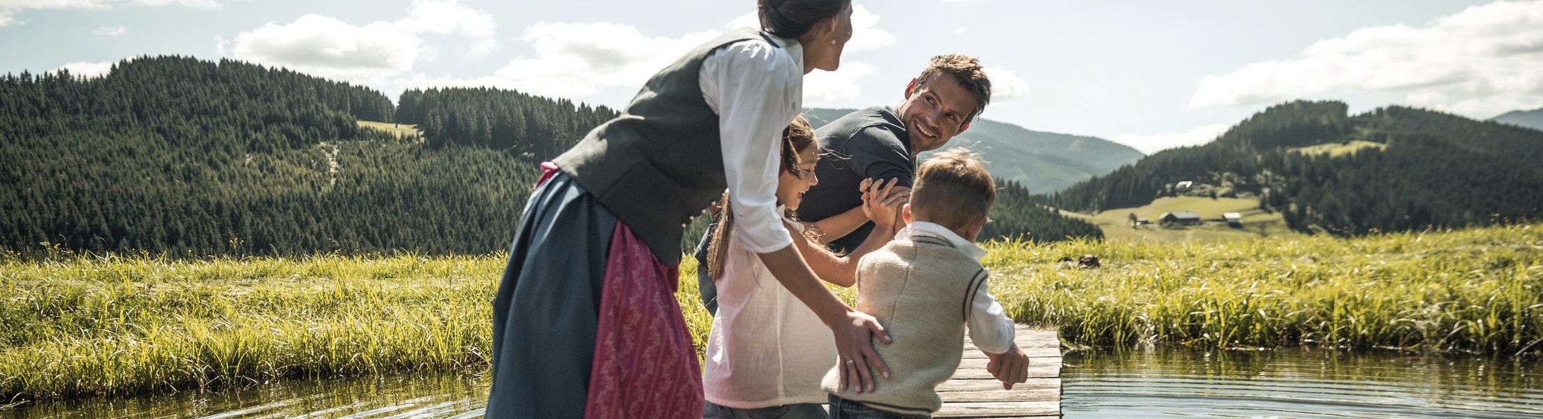 Familie rennt über Steg am auf See im Lammertal